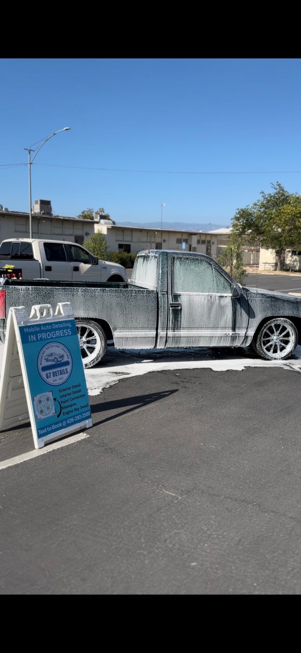 Pickup truck covered in foam beside the 67 Details sign