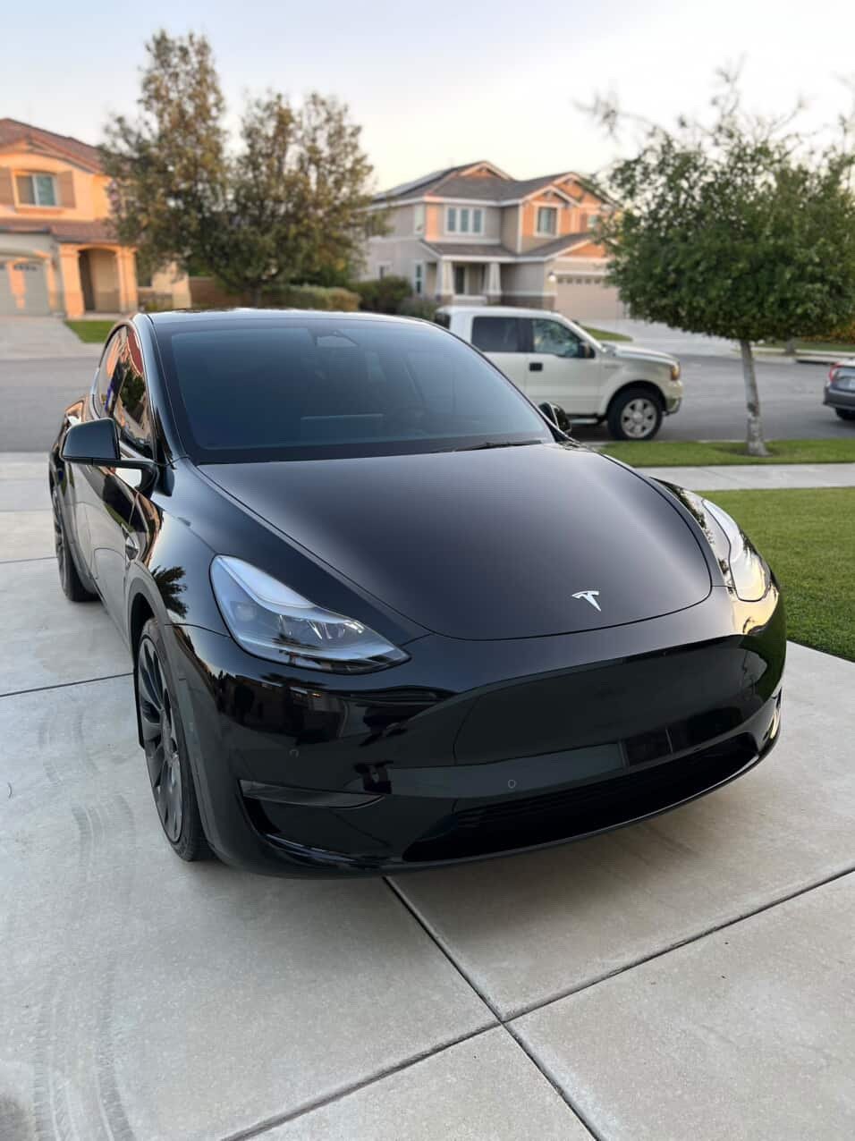 Glossy black Tesla parked on a residential driveway